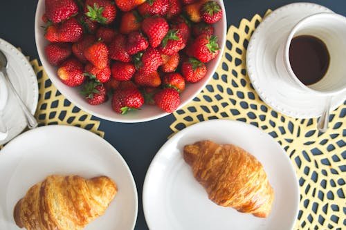 Free Top-down view of fresh croissants and strawberries with coffee on a breakfast table. Stock Photo