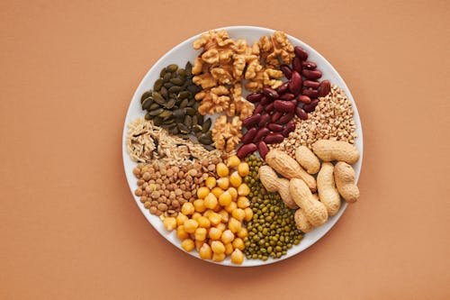 Free Top view of nuts, beans, and seeds on a plate, ideal for healthy dining themes. Stock Photo